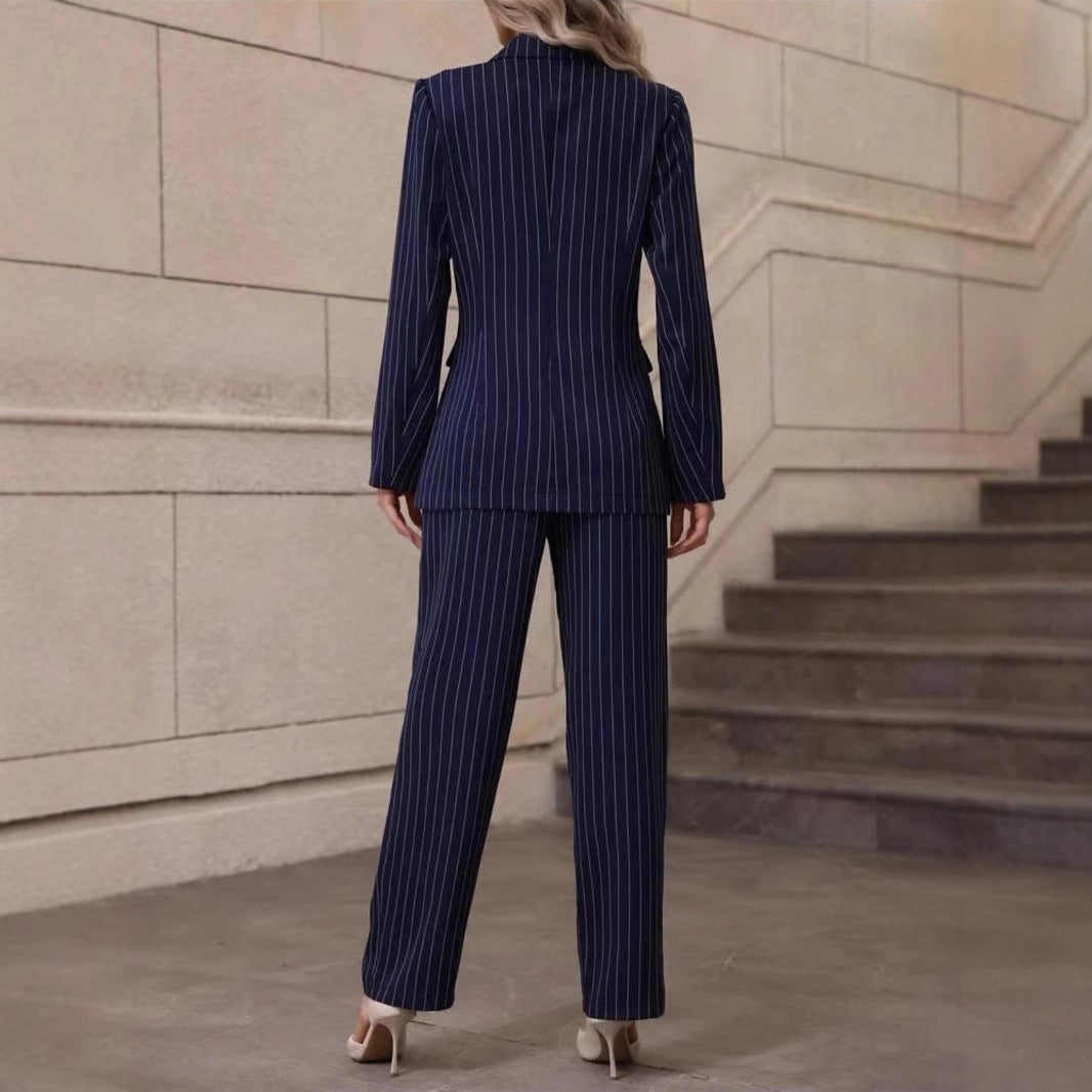 Frau im eleganten, dunkelblauen Nadelstreifenanzug, steht auf Treppe. Businessmode, stilvoll, professionell, Rückansicht.