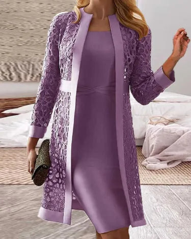 Frau in lila Spitzenkleid und passendem Mantel, hält eine schwarze Clutch. Elegante Mode, Abendgarderobe, stilvolles Outfit für besondere Anlässe.