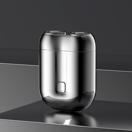 Moderner elektrischer Rasierer aus Edelstahl mit zwei Scherköpfen auf reflektierender Oberfläche, ideal für präzise und komfortable Rasur.