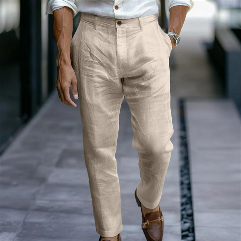 Eleganter Mann in beiger Leinenhose und braunen Lederschuhen, gehend auf modernem Gehweg. Stilvolle Herrenmode, Sommeroutfit, Freizeitlook.