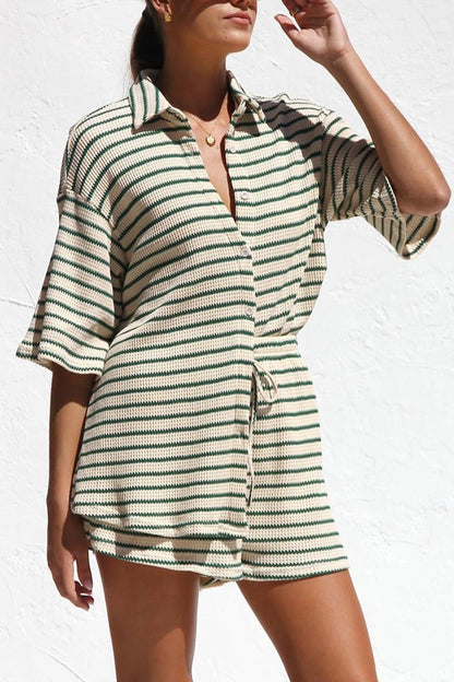 Frau in gestreiftem Sommerkleid vor weißer Wand, modisches Outfit, lässiger Stil, Sommermode, gestreiftes Design, Freizeitkleidung.