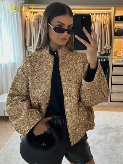 Frau in goldener Paillettenjacke macht Selfie im Ankleidezimmer, trägt schwarze Sonnenbrille und Lederhose. Mode, Glamour, Selfie, Ankleidezimmer.