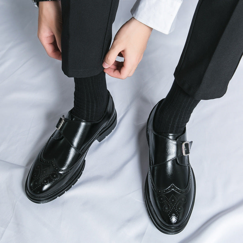 Schwarze Lederschuhe mit Schnalle, getragen von einer Person in schwarzer Hose und Socken. Elegante Herrenschuhe, stilvoll und modern.