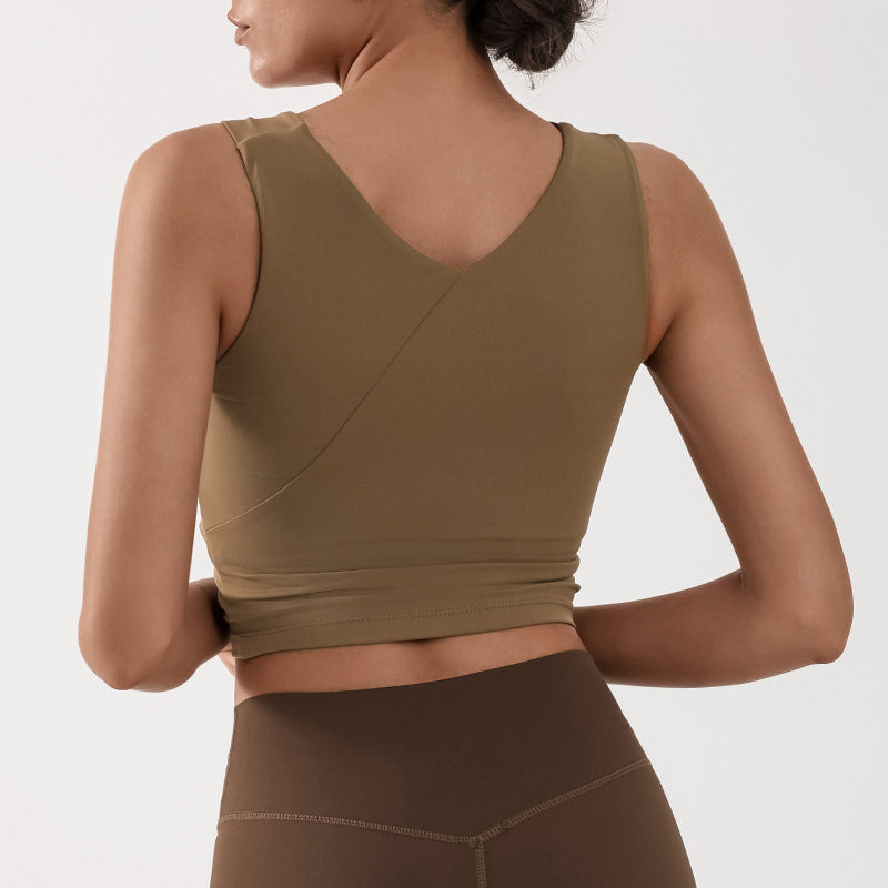 Frau in olivgrünem Sporttop und brauner Leggings von hinten, Fitnessmode, athletische Kleidung, nahtloses Design, bequeme Sportbekleidung.