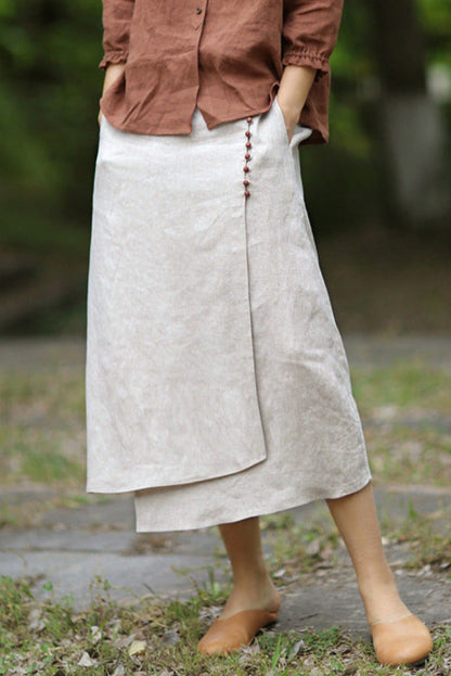 Damenrock aus Leinen in Beige, knielang, mit seitlichen Knöpfen. Perfekt für Sommermode, lässiger Stil, kombiniert mit brauner Bluse.