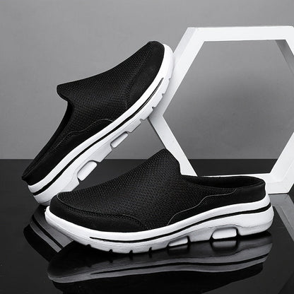 Schwarze Herren-Sneaker ohne Schnürsenkel, atmungsaktiv, mit weißer Sohle, auf schwarzem und grauem Hintergrund, modisch und bequem.