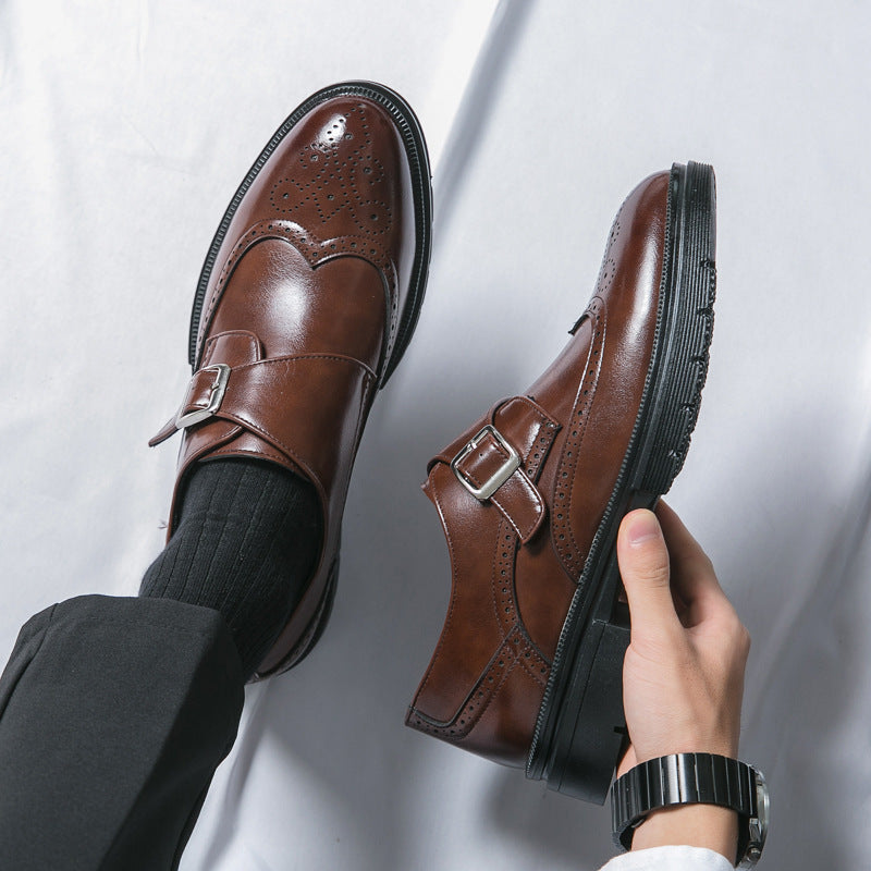 Braune Herren-Monkstrap-Schuhe aus Leder, elegante Brogue-Details, schwarze Sohle, getragen mit schwarzen Socken und Anzughose, stilvoll und modern.