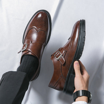 Braune Herren-Monkstrap-Schuhe aus Leder, elegante Brogue-Details, schwarze Sohle, getragen mit schwarzen Socken und Anzughose, stilvoll und modern.