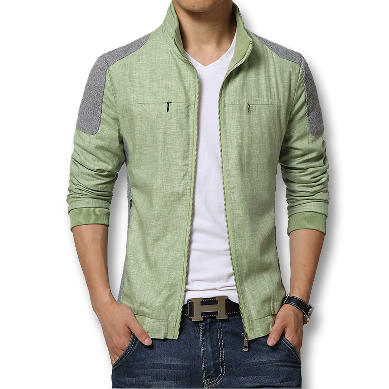 Mann in grüner Freizeitjacke mit Reißverschluss, weißem T-Shirt und blauer Jeans. Modische Herrenbekleidung, lässiger Stil, moderne Mode.