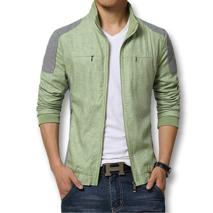 Mann in grüner Freizeitjacke mit Reißverschluss, weißem T-Shirt und blauer Jeans. Modische Herrenbekleidung, lässiger Stil, moderne Mode.