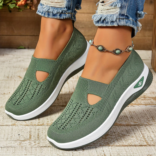Grüne Damen-Sneaker mit Strickmuster, dicker weißer Sohle und Cut-Out-Design, getragen mit zerrissenen Jeans und einem türkisfarbenen Fußkettchen.