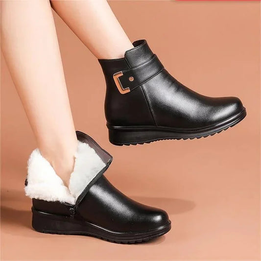 Schwarze Damen-Winterstiefel mit Kunstfellfutter, seitlichem Reißverschluss und dekorativer Schnalle, ideal für kalte Tage.
