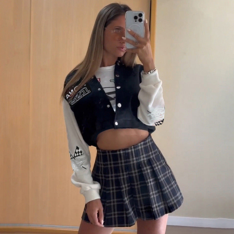 Junge Frau im karierten Rock und Collegejacke macht Selfie im Spiegel. Modetrend, Streetstyle, lässiges Outfit, modische Kleidung.