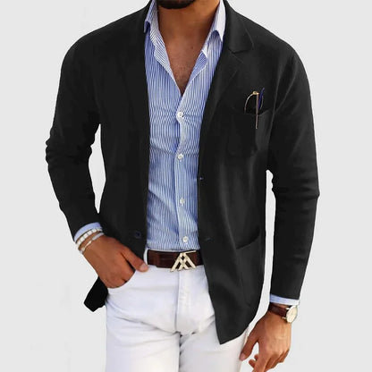 Mann in schwarzem Blazer, blau-weiß gestreiftem Hemd und weißer Hose. Eleganter Business-Look, modisch, stilvoll, Herrenmode.