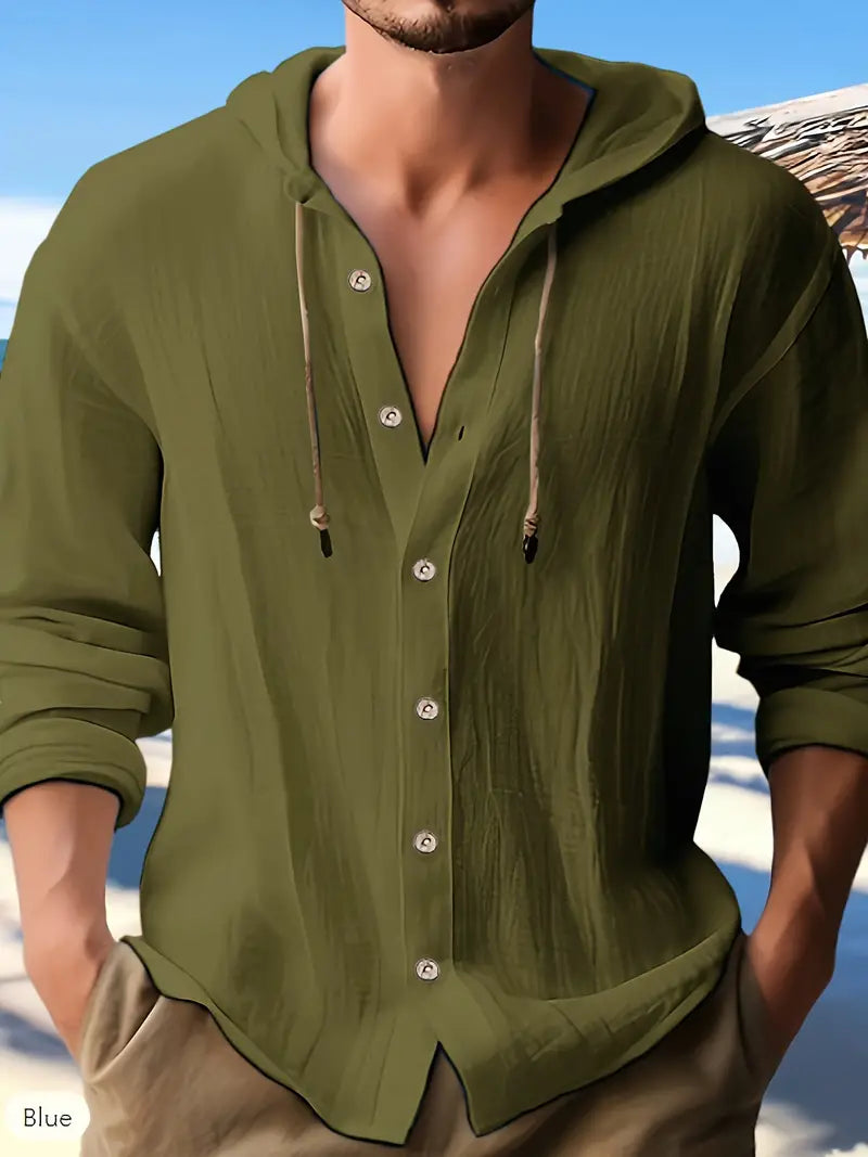 Mann in olivgrünem Leinenhemd mit Kapuze am Strand, lässiger Sommerlook, Herrenmode, Freizeitkleidung, Urlaub, stilvoll, entspannt.