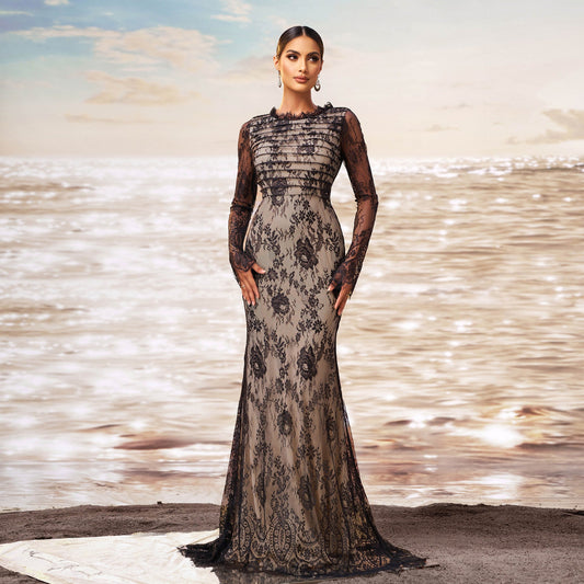 Elegante Frau in schwarzem Spitzenkleid am Strand bei Sonnenuntergang, modisches Abendkleid, stilvolle Abendmode, glamouröse Strandkulisse.