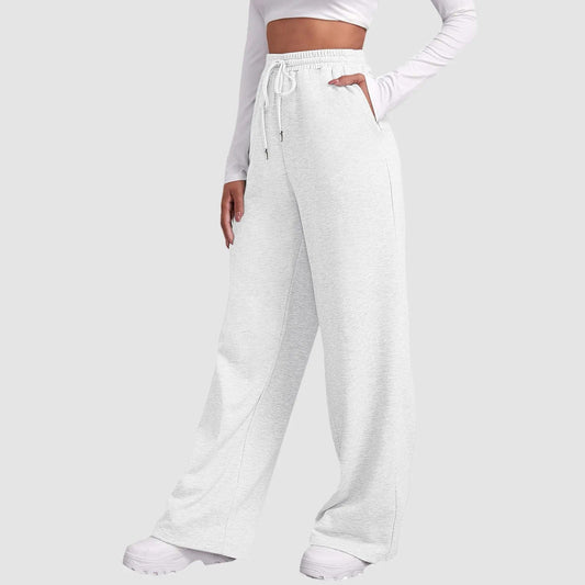 Frau in weißen, weiten Jogginghosen und weißem Langarmshirt, sportlich-eleganter Look, bequeme Freizeitmode, ideal für Damen, modische Sportbekleidung.