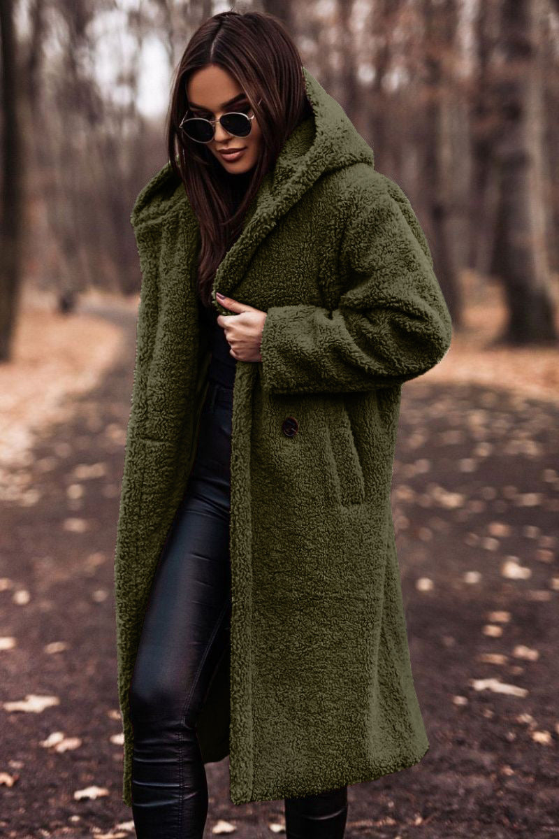 Frau im grünen Teddy-Mantel, schwarze Sonnenbrille, Lederhose, Herbstwald. Modetrend, Herbstmode, stilvoller Look, Outdoor-Fashion.