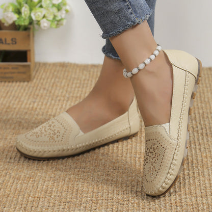 Beige Damen-Loafer aus Leder mit Lochmuster, getragen mit Jeans und Perlenfußkettchen, auf Juteteppich. Elegante, bequeme Freizeitschuhe.