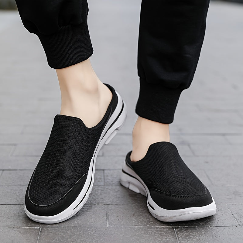 Schwarze Slip-On-Sneaker auf grauem Gehweg, getragen von Person in schwarzer Hose. Bequeme Freizeitschuhe, atmungsaktiv, ideal für Alltag und Sport.
