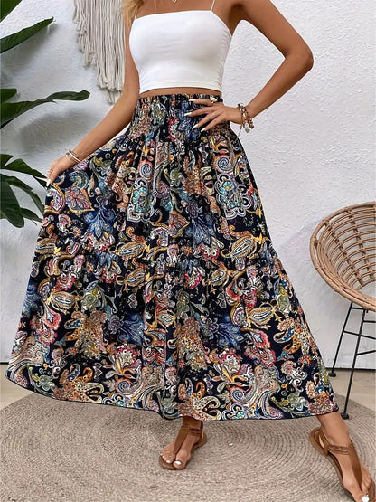 Frau in weißem Top und langem, buntem Boho-Rock mit Paisley-Muster, steht auf Terrasse. Sommermode, Boho-Chic, Damenbekleidung.