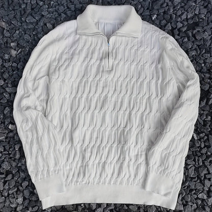 Weißer Strickpullover mit Reißverschluss auf dunklem Kies. Modischer Herrenpullover, ideal für Herbst und Winter. Elegantes Strickmuster.