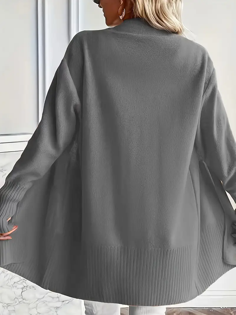 Frau trägt grauen Strick-Cardigan, Rückansicht. Modischer Damenpullover, lässiger Stil, Herbst-Winter-Bekleidung, gemütliche Oberbekleidung.