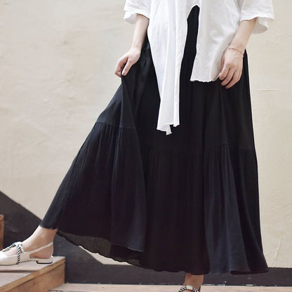 Frau in weißem Oberteil und langem schwarzem Rock auf Treppe. Modetrend, Damenmode, eleganter Look, Sommeroutfit, stilvolle Kleidung.