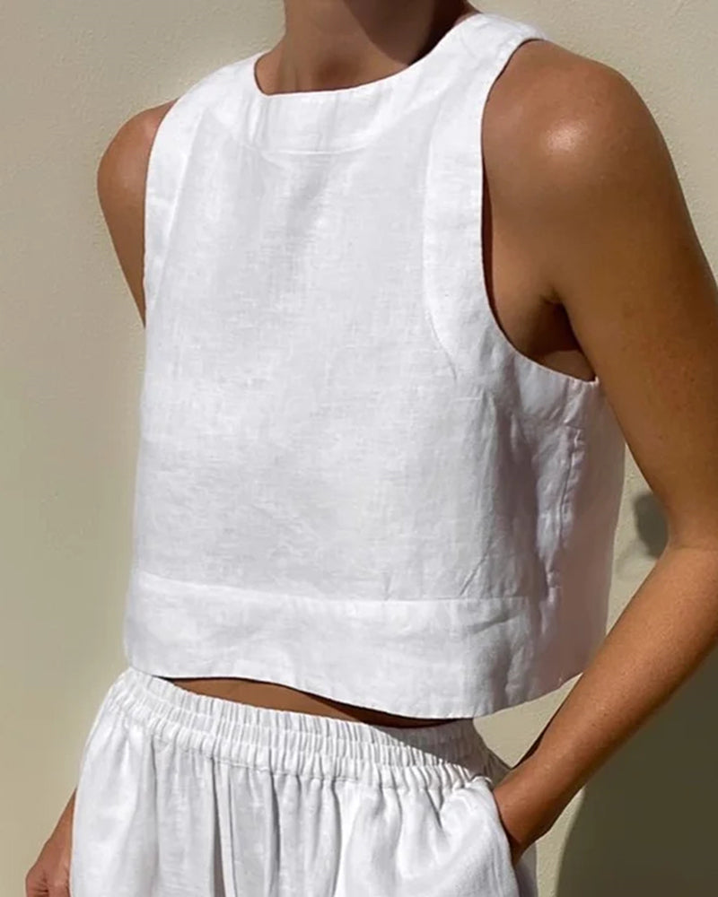 Weiße Leinenbluse und Shorts, ärmelloses Design, minimalistischer Sommerlook, Damenmode, atmungsaktiver Stoff, eleganter Freizeitstil.