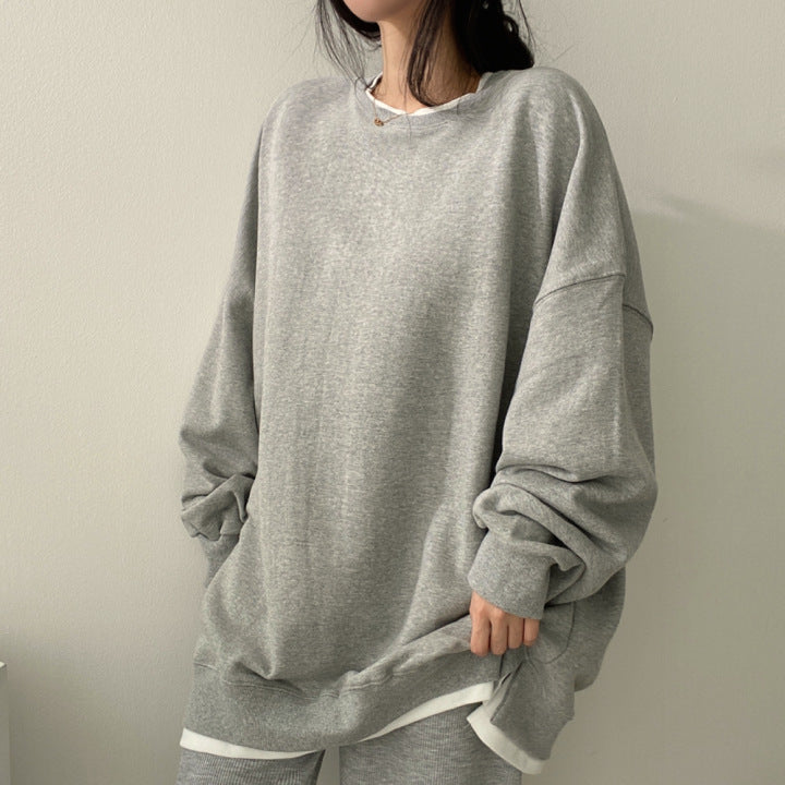Graues Oversize-Sweatshirt, lässig getragen von Frau. Modetrend, bequeme Freizeitkleidung, minimalistisch, gemütlicher Look.