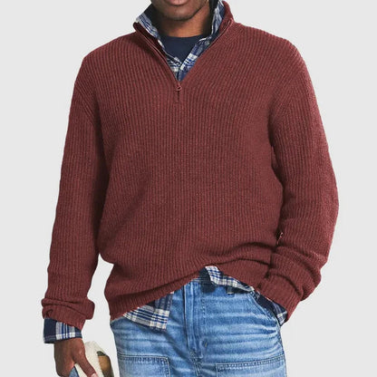 Mann in rotem Strickpullover mit Reißverschluss, kariertem Hemd und blauer Jeans. Modischer Freizeitlook für Herren.