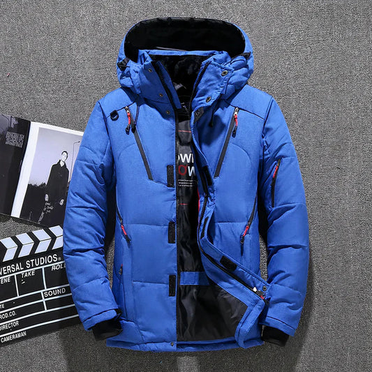 Blaue Winterjacke mit Kapuze, Reißverschlüssen und Taschen, ideal für Outdoor-Aktivitäten. Stilvoll und warm, perfekt für kalte Temperaturen.