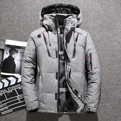 Graue Winterjacke mit Kapuze, Reißverschlüssen und Taschen auf grauem Hintergrund. Moderne Herrenmode, warm und stilvoll für kalte Tage.
