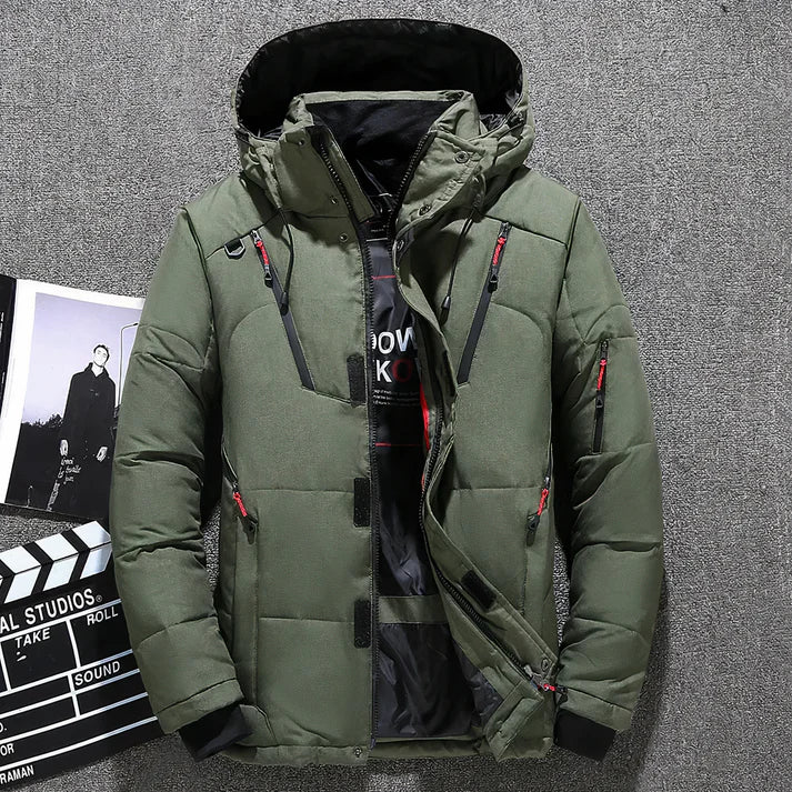 Grüne Winterjacke mit Kapuze, Reißverschlüssen und Taschen auf grauem Hintergrund. Stilvolle Outdoor-Bekleidung für kalte Temperaturen.