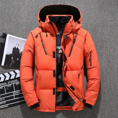 Orangefarbene Winterjacke mit Kapuze, Reißverschlüssen und Taschen, auf grauem Hintergrund. Perfekt für kaltes Wetter, modisch und funktional.