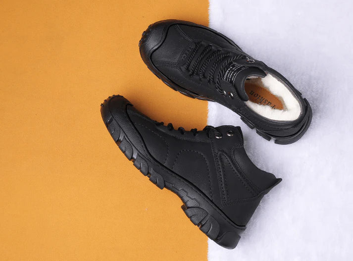 Schwarze Winterstiefel mit dicker Sohle und warmem Innenfutter auf zweifarbigem Hintergrund. Outdoor-Schuhe, wasserdicht, rutschfest.