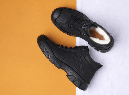 Schwarze Winterstiefel mit dicker Sohle und warmem Innenfutter auf zweifarbigem Hintergrund. Outdoor-Schuhe, wasserdicht, rutschfest.