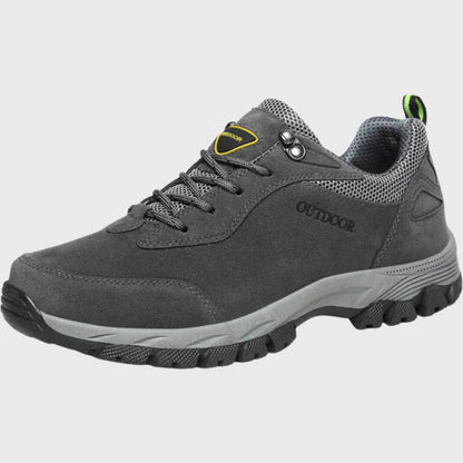 Grauer Outdoor-Wanderschuh mit rutschfester Sohle, atmungsaktivem Mesh-Einsatz und robustem Design für Herren. Ideal für Trekking und Hiking.