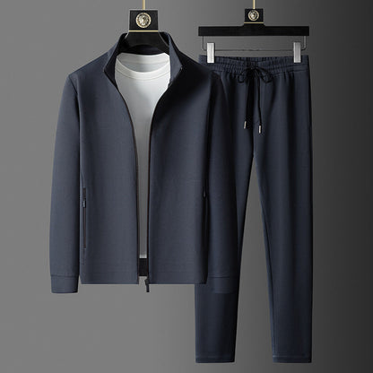 Dunkelblauer Herren-Trainingsanzug mit Reißverschlussjacke und Jogginghose, auf grauem Hintergrund. Sportbekleidung, Freizeitmode, Herrenmode.