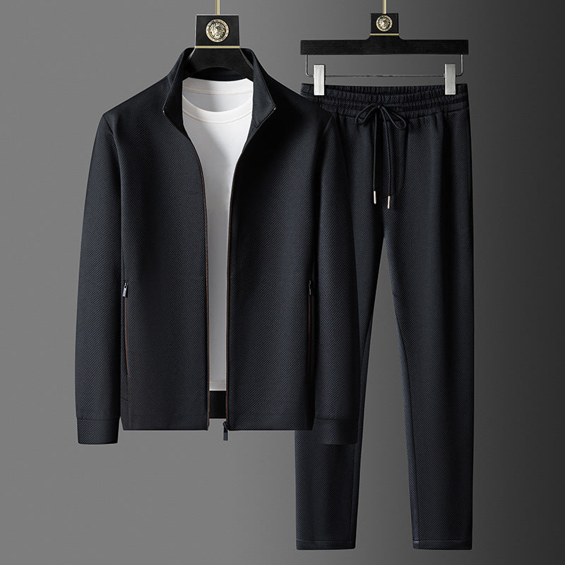Schwarzer Herren-Trainingsanzug mit Reißverschlussjacke und Jogginghose, kombiniert mit weißem T-Shirt. Sportbekleidung, Freizeitmode, Herrenoutfit.