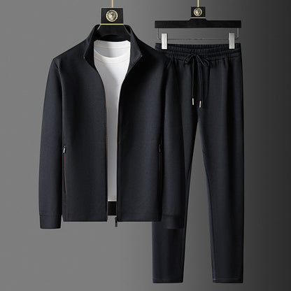 Schwarzer Herren-Trainingsanzug mit Reißverschlussjacke und Jogginghose, kombiniert mit weißem T-Shirt. Sportbekleidung, Freizeitmode, Herrenoutfit.