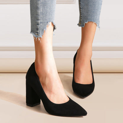 Damenfüße in zerrissenen Jeans und schwarzen High Heels mit Blockabsatz auf hellem Boden. Elegante Schuhe, modische Damenmode, stilvolle Absatzschuhe.