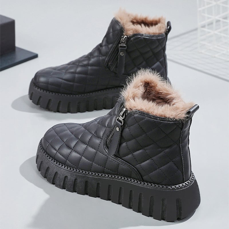 Schwarze, gesteppte Winterstiefel mit Reißverschluss und flauschigem Innenfutter auf weißem Hintergrund. Damenmode, warme Schuhe, Wintertrends.