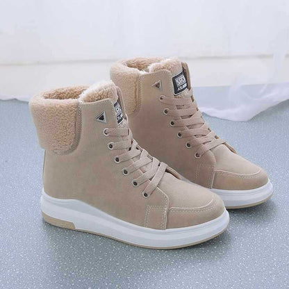 Beige Winterstiefel mit Fellfutter, rutschfeste Sohle und Schnürung auf grauem Boden. Damenmode, warme Schuhe, stilvolle Winterschuhe.