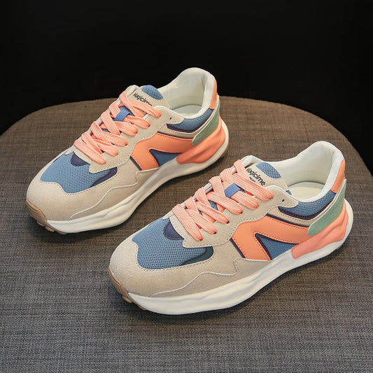 Bunte Sneaker auf grauem Hintergrund, mit blauen, orangefarbenen und beigen Akzenten. Modische Sportschuhe, ideal für Freizeit und Sport.