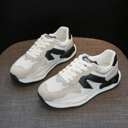 Weiße und graue Sneaker mit schwarzem Detail auf grauem Hintergrund. Modische Sportschuhe, bequeme Turnschuhe, ideal für Freizeit und Sport.