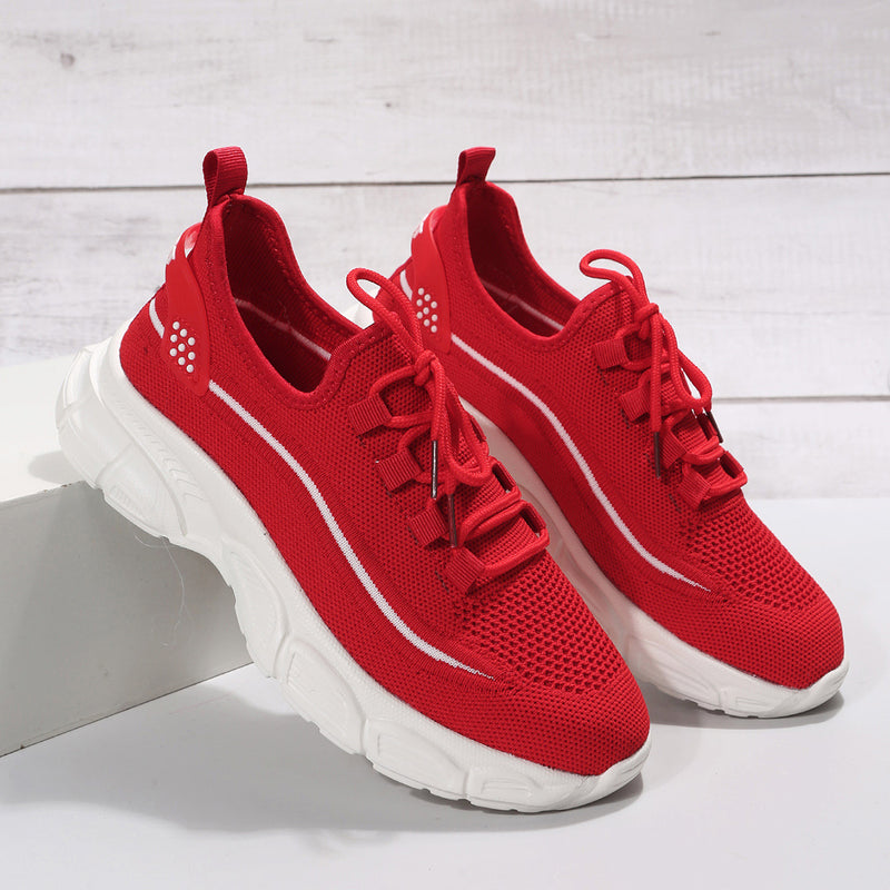 Rote Sportschuhe mit weißer Sohle auf weißem Hintergrund, modernes Design, atmungsaktives Mesh, ideal für Laufen und Fitness.