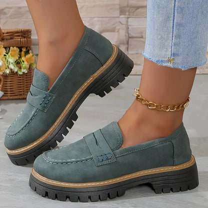 Damen Loafer in Grün mit dicker Sohle, kombiniert mit Jeans und goldener Fußkette. Modische Schuhe für Herbst, bequem und stilvoll.