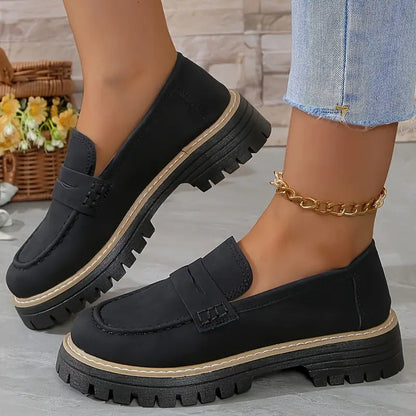 Schwarze Damen-Loafer mit dicker Sohle, getragen mit hellblauen Jeans. Modische Schuhe, ideal für Herbsttrends und lässige Outfits.