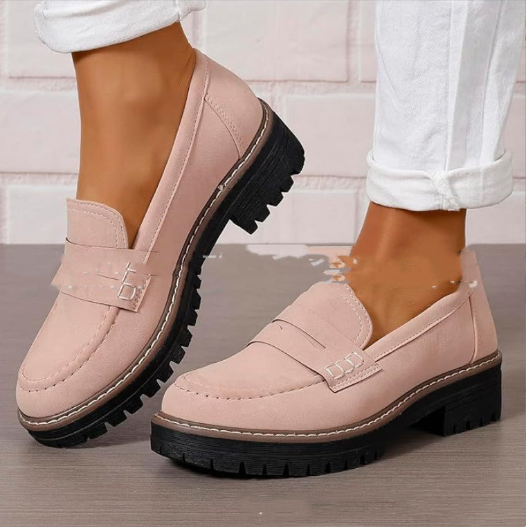 Damen Loafer in Rosa mit dicker, schwarzer Sohle, getragen zu weißen Hosen. Modische, bequeme Schuhe für Alltag und Büro.